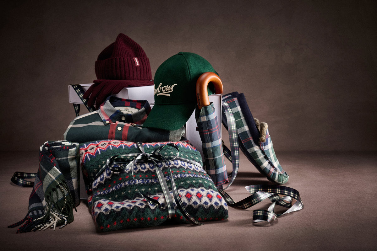 Barbour gifts for the season: tartan scarves, a burgundy beanie, a green cap, a Fair Isle knit and tartan ribbon