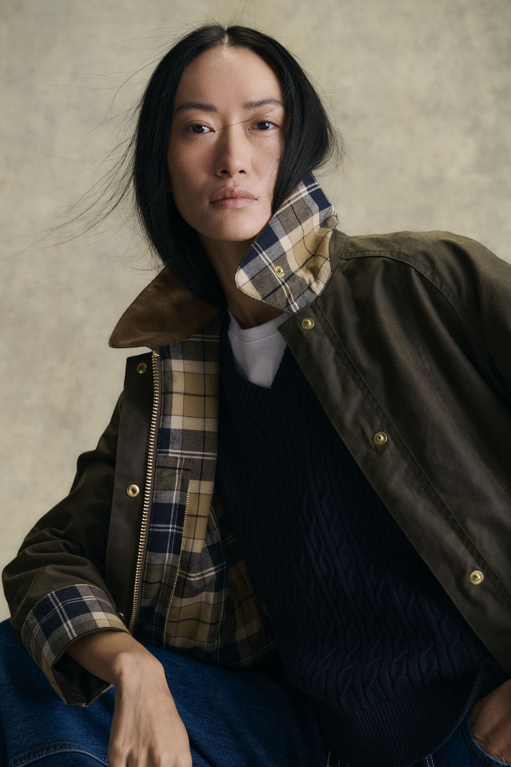 Woman in a Barbour Beadnell waxed jacket with the tartan collar turned up