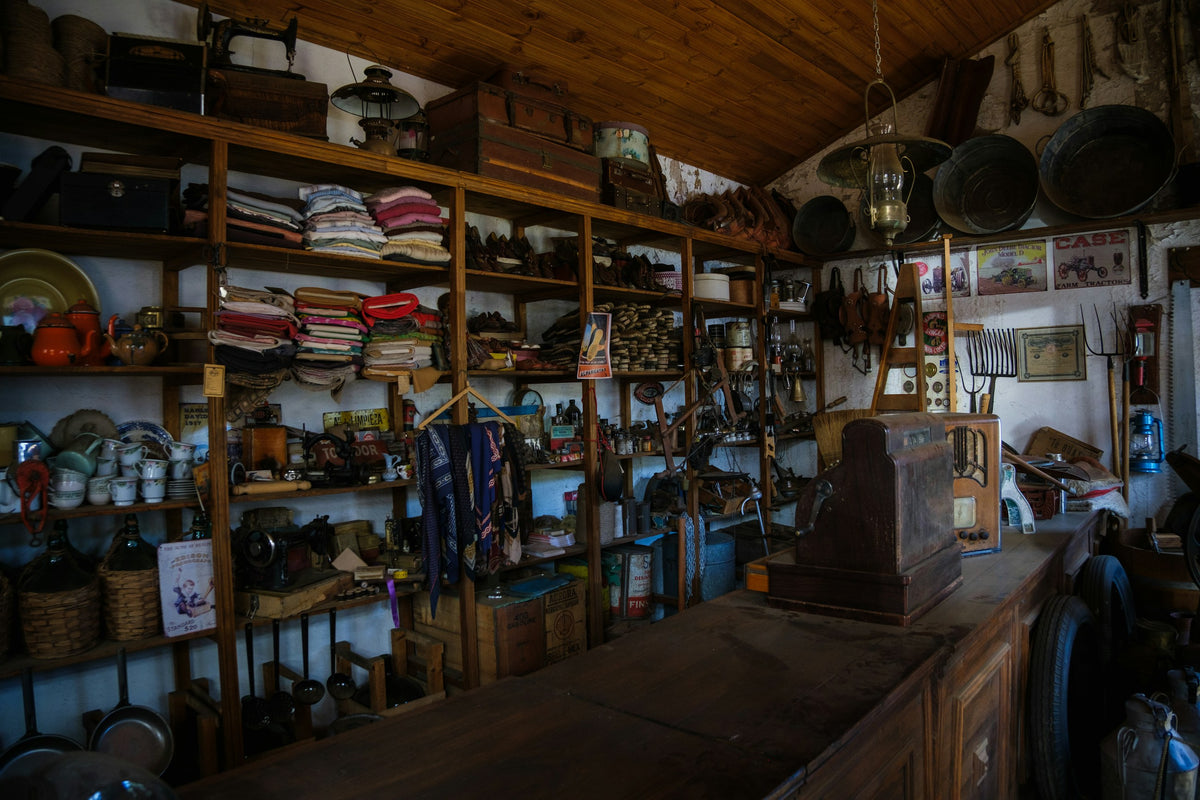 Shelves of an old general store stacked with linens, baskets and tins